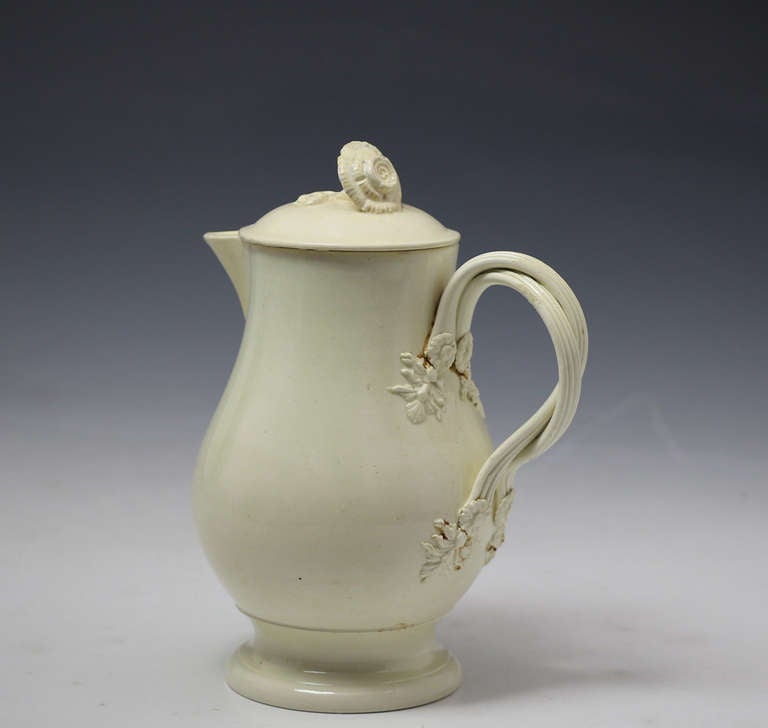 A fine example of a creamware pottery water jug with cover from the 18th century period. 
The cover has a flower shape finial.The double strap work handle is very elegant with floret and leaf terminals. 

Provenance:  Private English Collection. 
