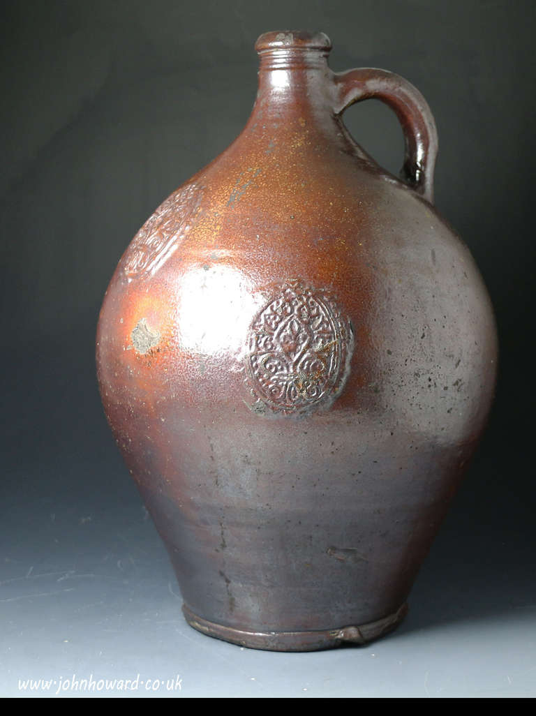 A large-sized 17th century stoneware flagon or bottle with seals bearing the date 1693. The flagon is a highly decorative and imposing example standing 15 inches high.
