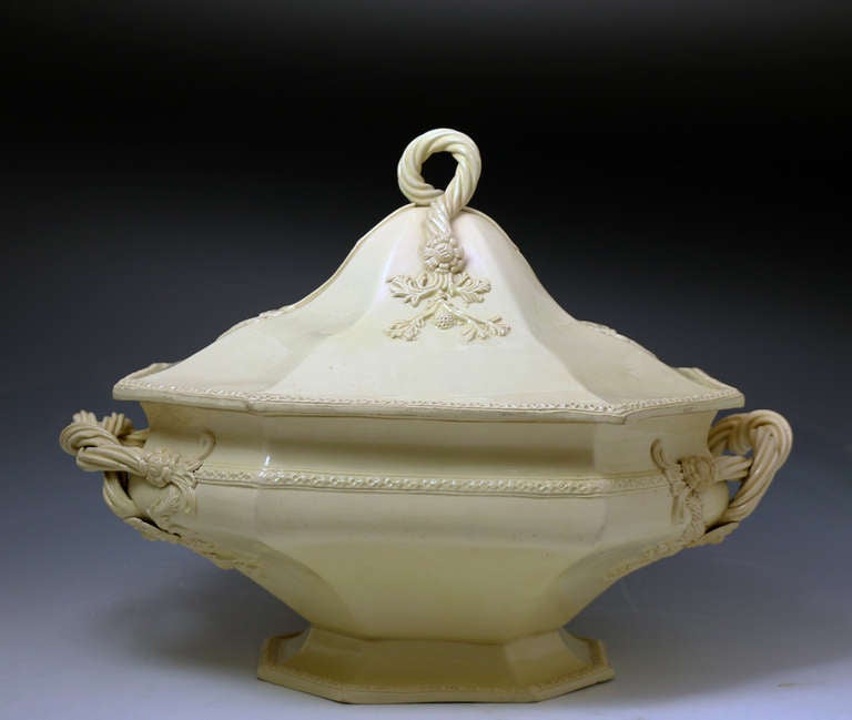 Antique creamware pottery melon tureen with a fixed leaf shaped stand and cover. The body colour is a definite cream 
and the tureen is very elegantly modelled with trailing vines and decorated with flowers and leaves in a dark matt purple. This