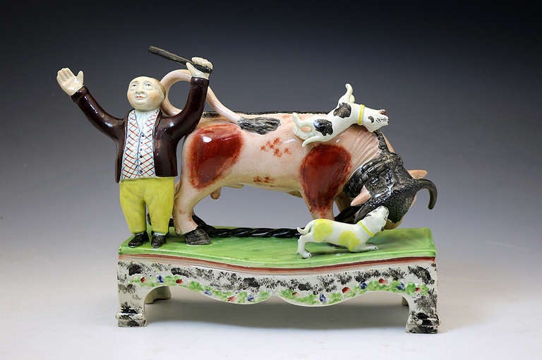 Antique Staffordshire figure of a bull baiting group on a table base by Obadiah Sherratt c1820. This figure is a very rare size and is boldly modelled and enamel coloured. 
The base is 9 inches long and is a rare four footed example. 
The figure