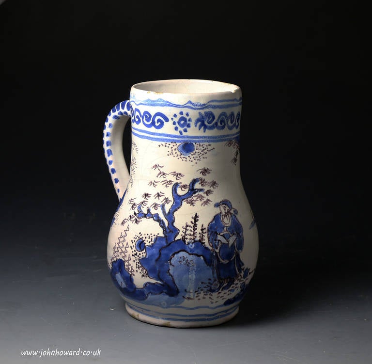 Antique late 17th century period English delftware tankard decorated in chinoiserie style in cobalt blue and manganese. The decoration of the figure, the rocks and trees is very well executed.
