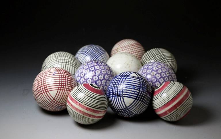 A set of antique pottery carpet balls with sponged decoration in various colors. <br />
The set comprises of five pairs and the illusive and rare white 