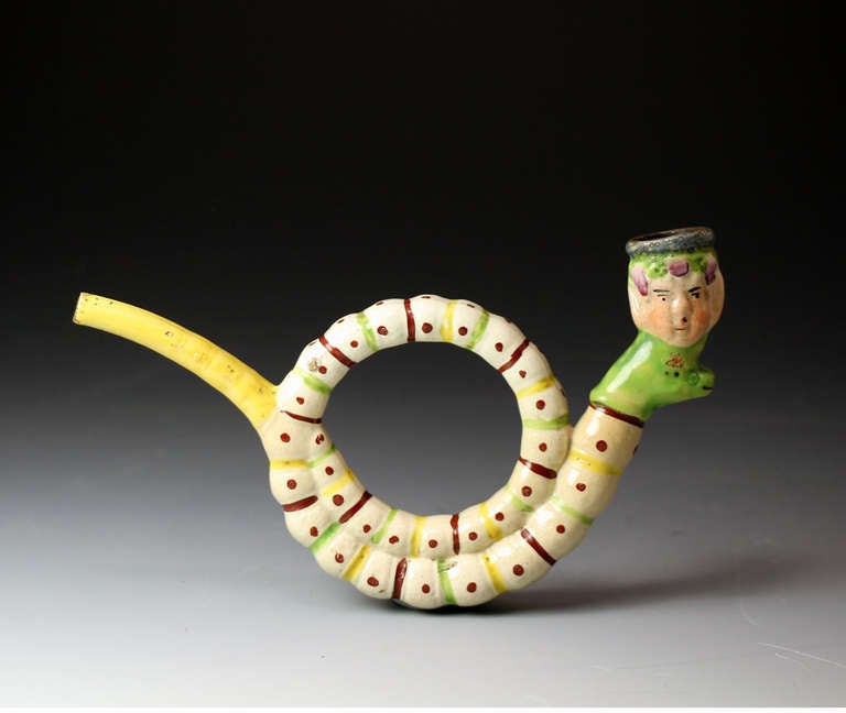 Antique English Staffordshire pottery pearlware figure of a pipe in the form of a snake and the figure of a head circa1820 

Antique English Staffordshire pottery pearlware figure of a pipe in the form of a snake and the figure of a head which