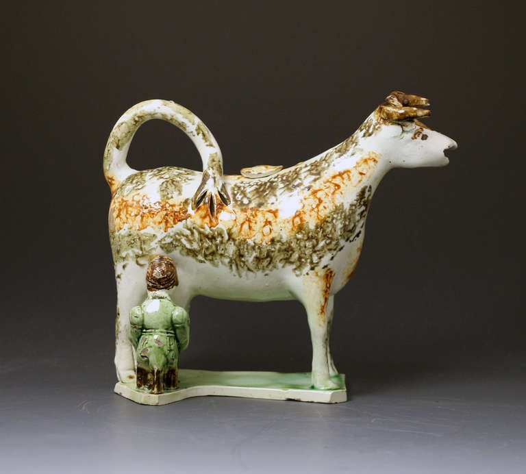 English pottery cow creamer with the figure of a milk maid antique, period circa 1800. 

Antique pottery cow creamer complete with the figure of a milking maid.
This creamer figure would date to the beginning of the 19th century
Classic early