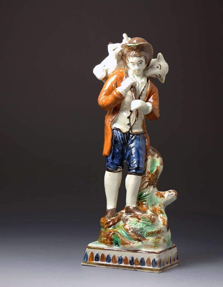 Early 19th Century 

Antique English Prattware pottery figure of a shepherd carrying a sheep on his shoulders. 
This charming pottery figure is known as the 
