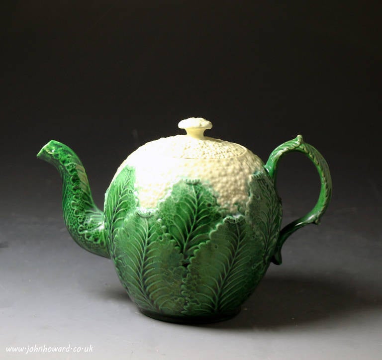 A good Staffordshire pottery creamware bodied teapot with cauliflower relief modelling and realistic lead glaze colours. 
Similar ware were produced in the mid-18th century by Whieldon, Wedgwood and Greatbach and this piece would have been the work