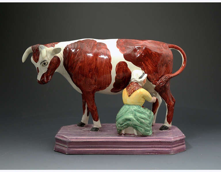 Large figure of a cow and milk maid with a pink luster base Staffordshire pottery England circa 1820 period. 

Large and rare figure of a cow and milk maid with a pink luster base Staffordshire pottery England circa 1820 period. The modelling and