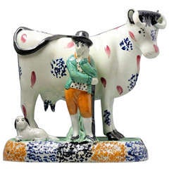 Antique Yorkshire pottery figure of a cow with farm hand in Pratt colours.