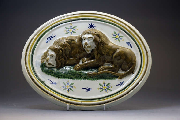 Prattware pottery relief moulded plaque with figures of two resting lions.c1800
