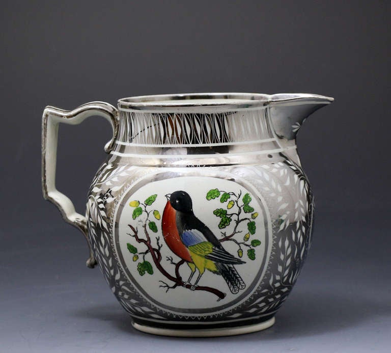 A rare silver luster resist decorated jug with an image of a robin in bright colours. 
The decoration of this pitcher is extremely well executed with both the silver resist and the figure of the robin. 
The silver lustre is in very fine unrubbed