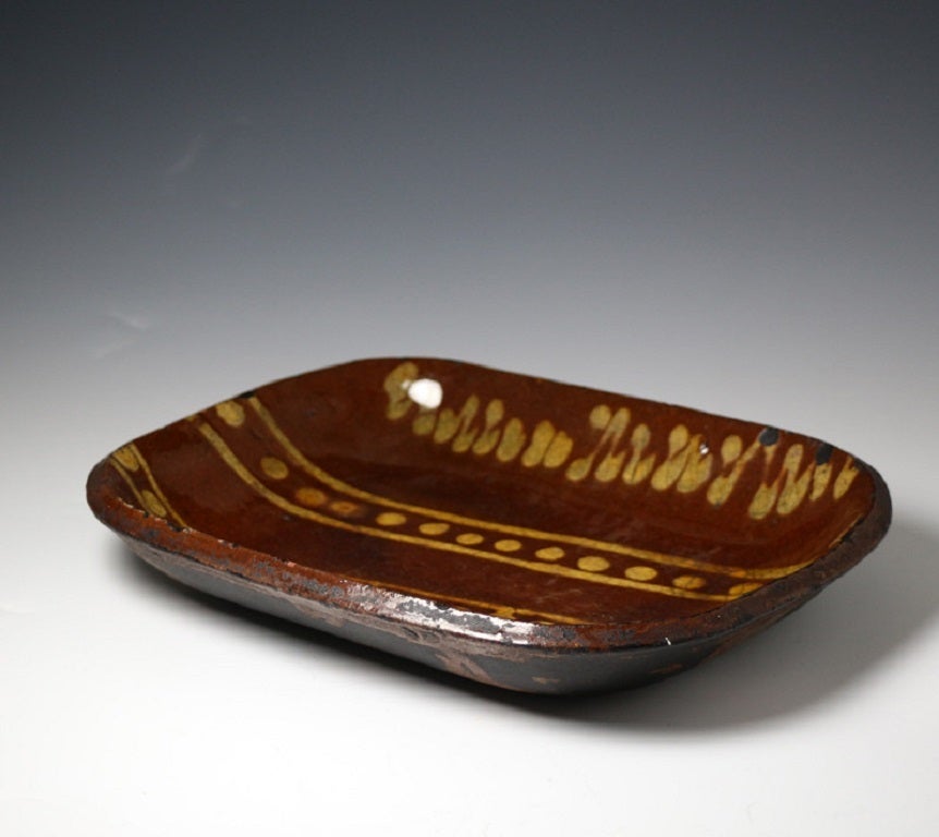 A good antique pottery slipware baking dish probably from the Staffordshire area in the late 18th century.