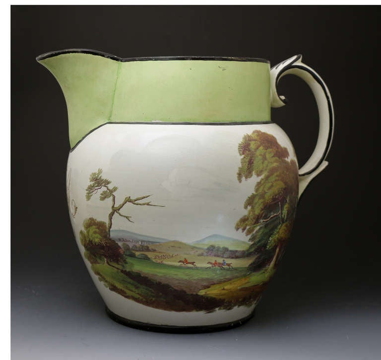 A large size antique pottery pitcher with well executed rural scenes one of a fox hunt with hounds in enamel colours. 
Probably Staffordshire pottery. The scale and quality of decoration gives this pitcher strong decorative impact and appeal. The