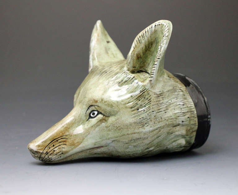 A striking, well modelled and large scale pottery fox head stirrup cup. 
The specific color palette, glaze and body of the stirrup cup indicate it's Scottish Pottery roots.