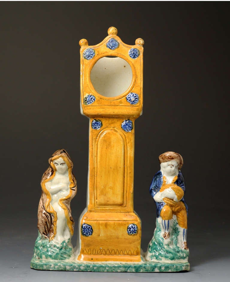 Antique English pottery watch holder in Prattware colours. 
The piece is naively modelled and vibrantly coloured with the Prattware pottery palette. 
This rare watch holder is very early 19th century period. 
Staffordshire, North East England or