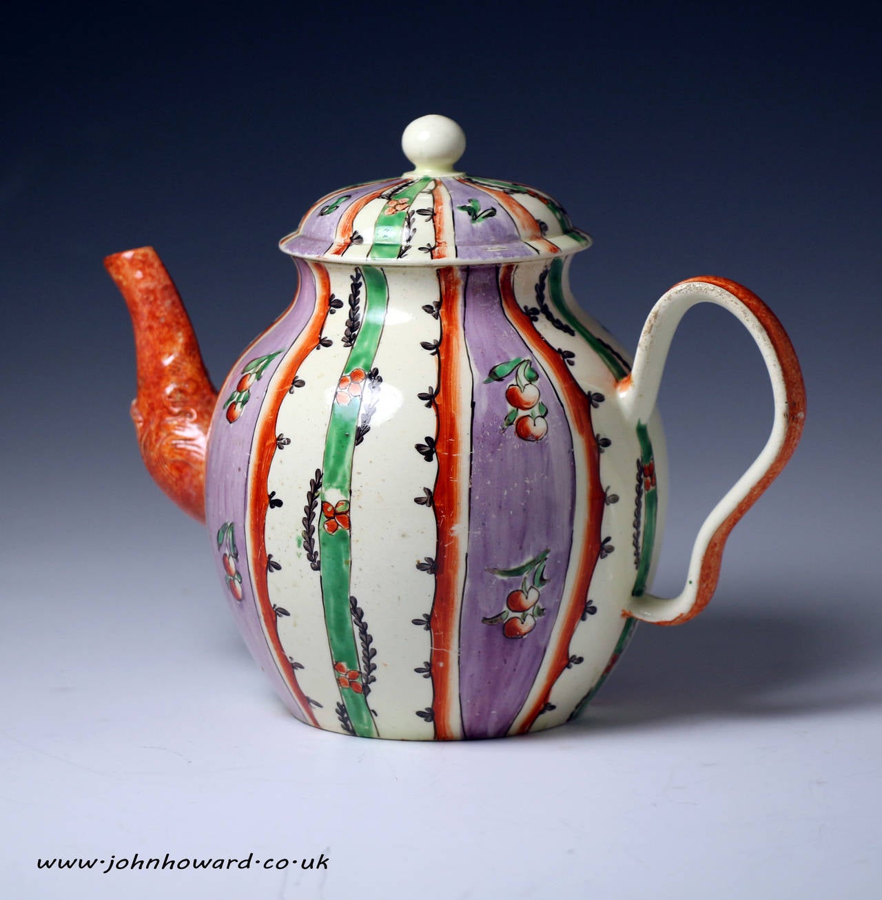A rare and highly decorative globe shaped Chintz patterned creamware teapot. 
The teapot is decorated with leaves, flowers and cherries within green, mauve and cream stripes. 
The ogee shaped handle and relief decorated spout are decorated in a