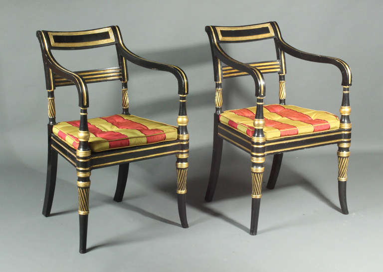 A handsome pair of Regency ebonised armchairs with gilt decoration. The gilding mainly original but restored.