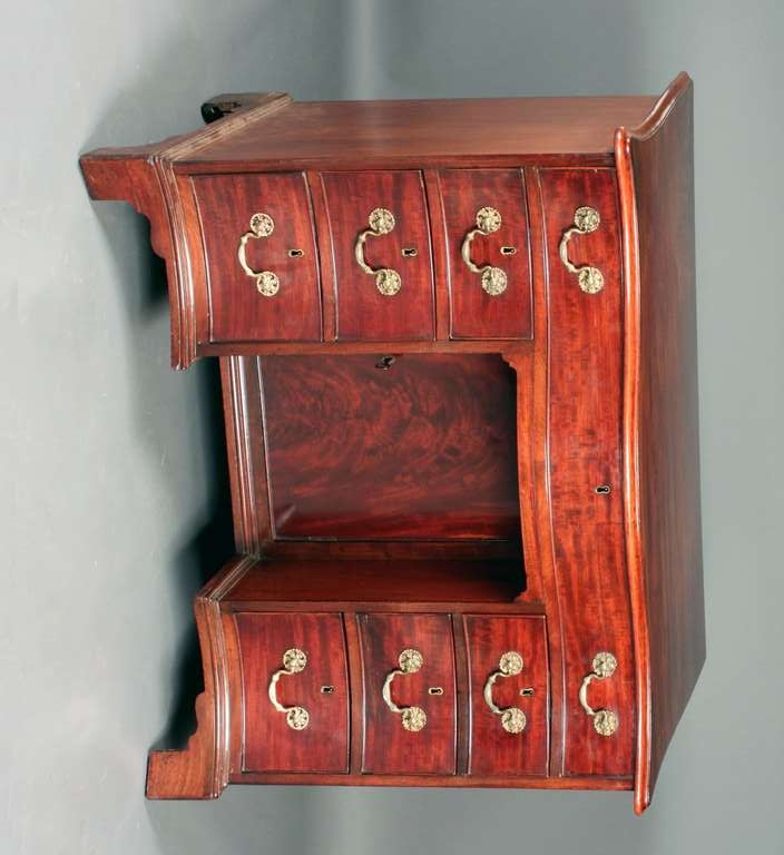 A George III serpentine fronted Chippendale period kneehole desk or dressing table in fiddle grain mahogany with most of the original fine swan neck handles.