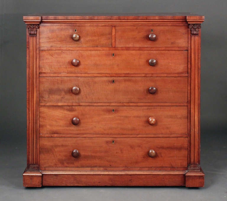 A near pair of fine quality chests of drawers in fiddle grain mahogany with oak drawer linings:
Well carved pilasters; one with Corinthian capitals, the other capitals carved leaves to resemble pineapple fronds.

Identical sized fronts: 46"