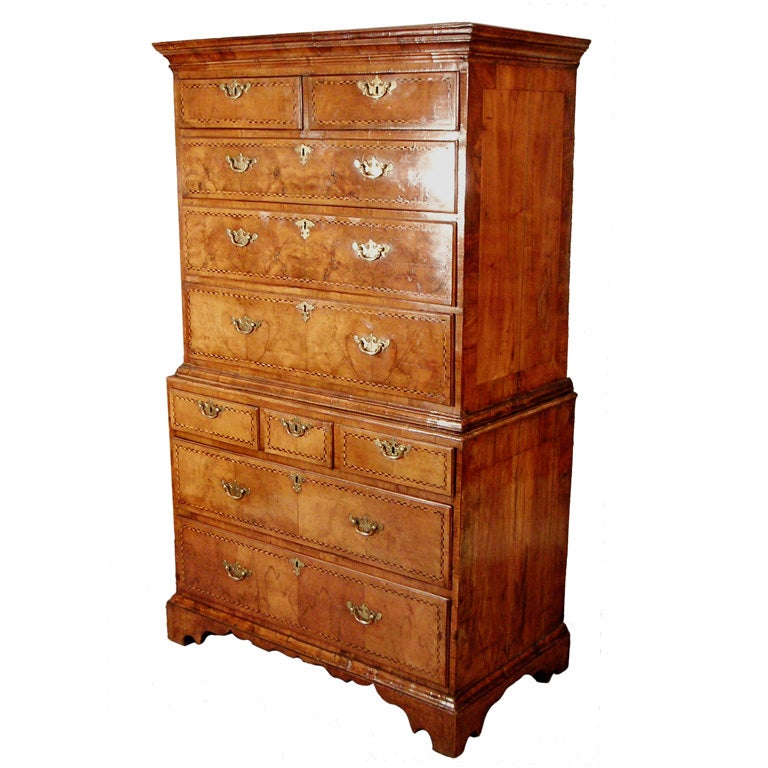 A good mid 18th Century figured tallboy in well-figured veneers with chevron banding and all the original brasses; unusual drawer arrangement, complex cross-grained mouldings and stepped bracket feet with a shaped frieze: good mellow colour. 