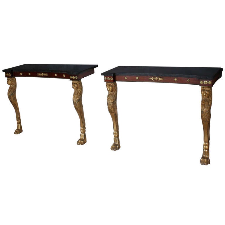 A fine pair of Regency console tables in the manner of Thomas Hope: gilt lion monopodia legs, rosewood frieze with brass mounts. The tops replaced in black sandstone which was often used with Irish furniture.
Provenance: A House near