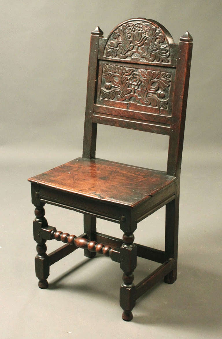 A 17th Century oak backstool with good original carving and of an excellent colour and patina