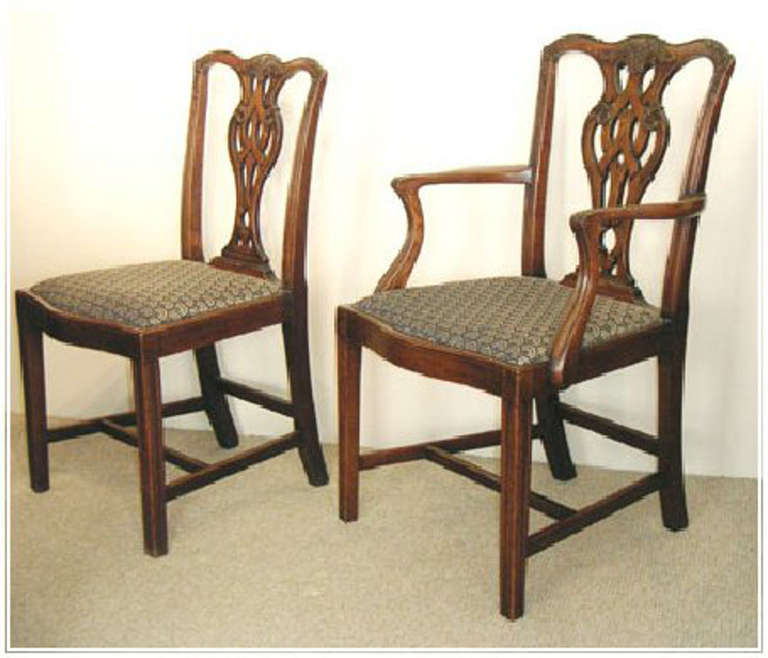 Set of eight Chippendale style dining chairs - including two armchairs. Well made and carved by Shoolbred of London in oak of a good mid-brown color. The armchairs significantly larger than the side chairs.