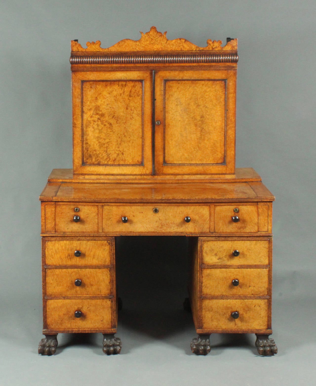 A rare Chinese-made desk made in amboyna wood with a fitted bookcase above; the centre drawer with a writing slope on a ratchet, the right hand drawer with a movable pen box. All the lower drawers lock with a clever mechanism accessed from the