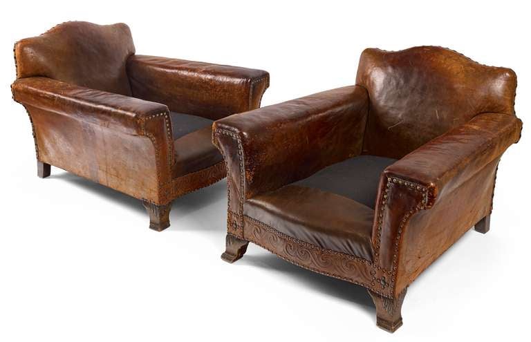 A pair of 1930's leather club chairs with unusually wide arms and deep proportions. These chairs have new duck/down cushions and are seriously comfortable.