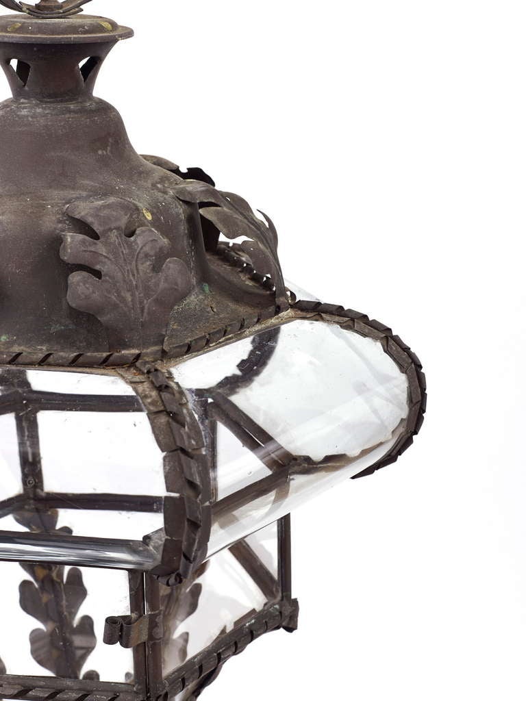 A Victorian wrought iron lantern of tapering form with wonderfully shaped glazing to the top.