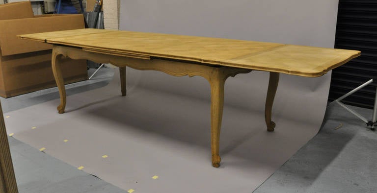 Late 19th Century, expandable bleached Oak table from Belgium. Parquet style top with scalloped edge details.
