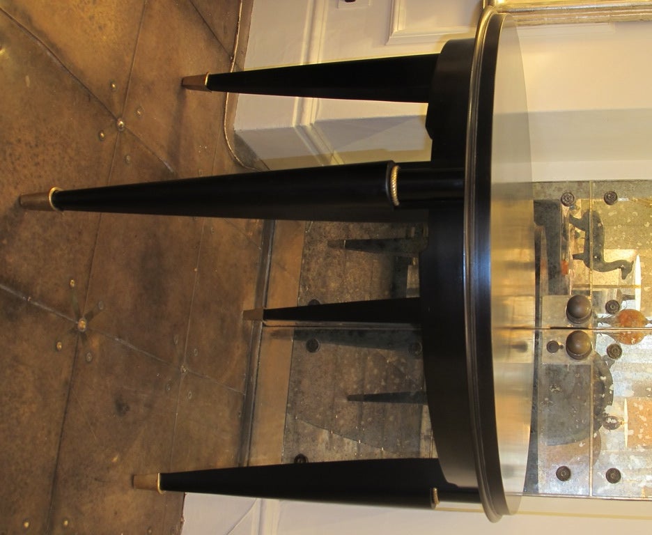 Black lacquered 1940's circular library table with brass feet.