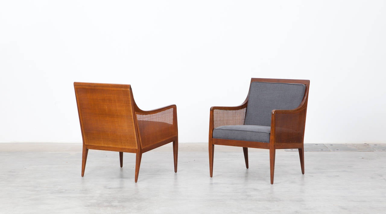 Elegant pair of Armchairs in solid walnut with caned back and sides designed by Kipp Stewart. The caning and wood are in excellent condition. The back cushion is removable for optimal use. Manufactured by Directional.