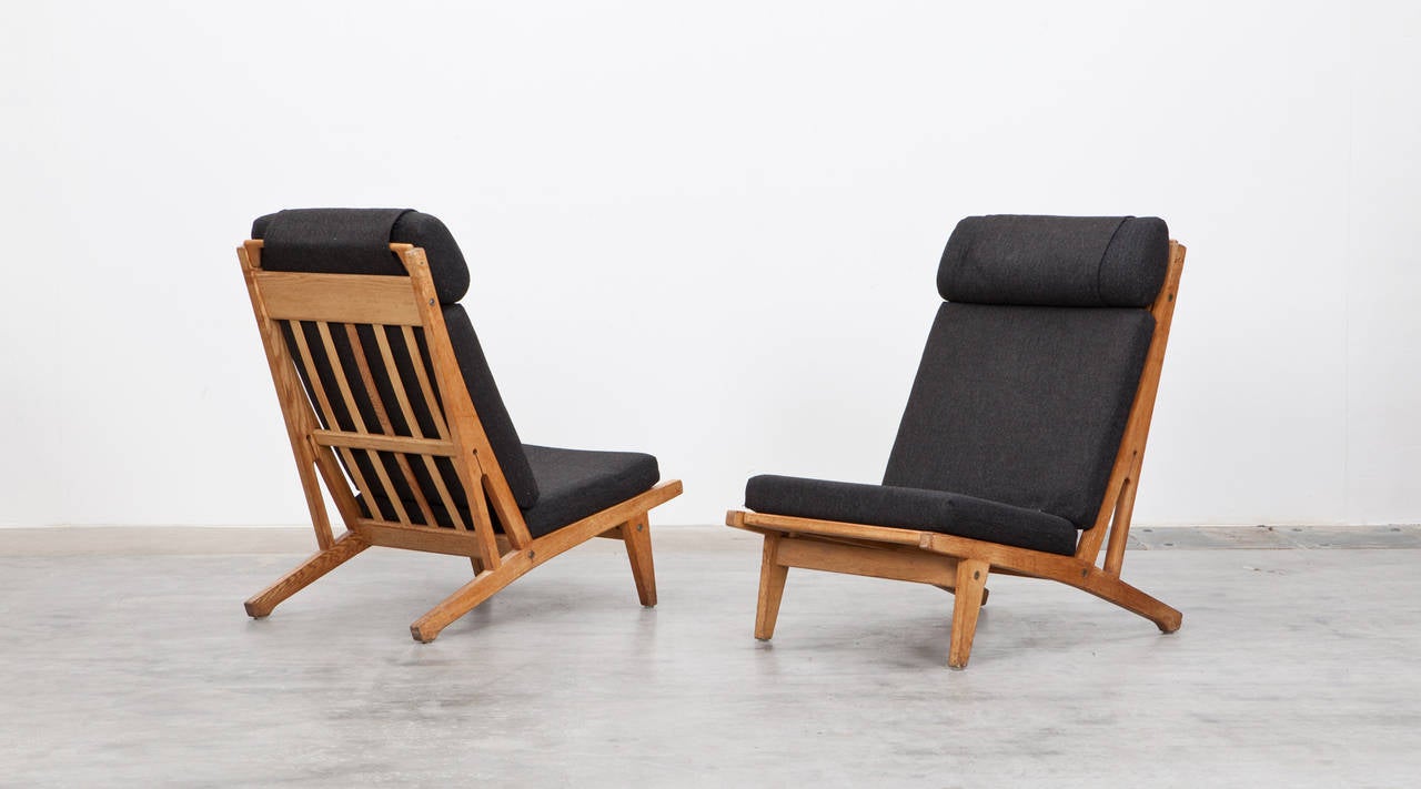 Delighting set of Hans Wegner lounge chairs. The simple white cushions underline the beautiful oak frame. Manufactured by Getama in 1951. After Wegner studied at the Arts and Crafts School in Copenhagen he got hired as draftsman for the architecture