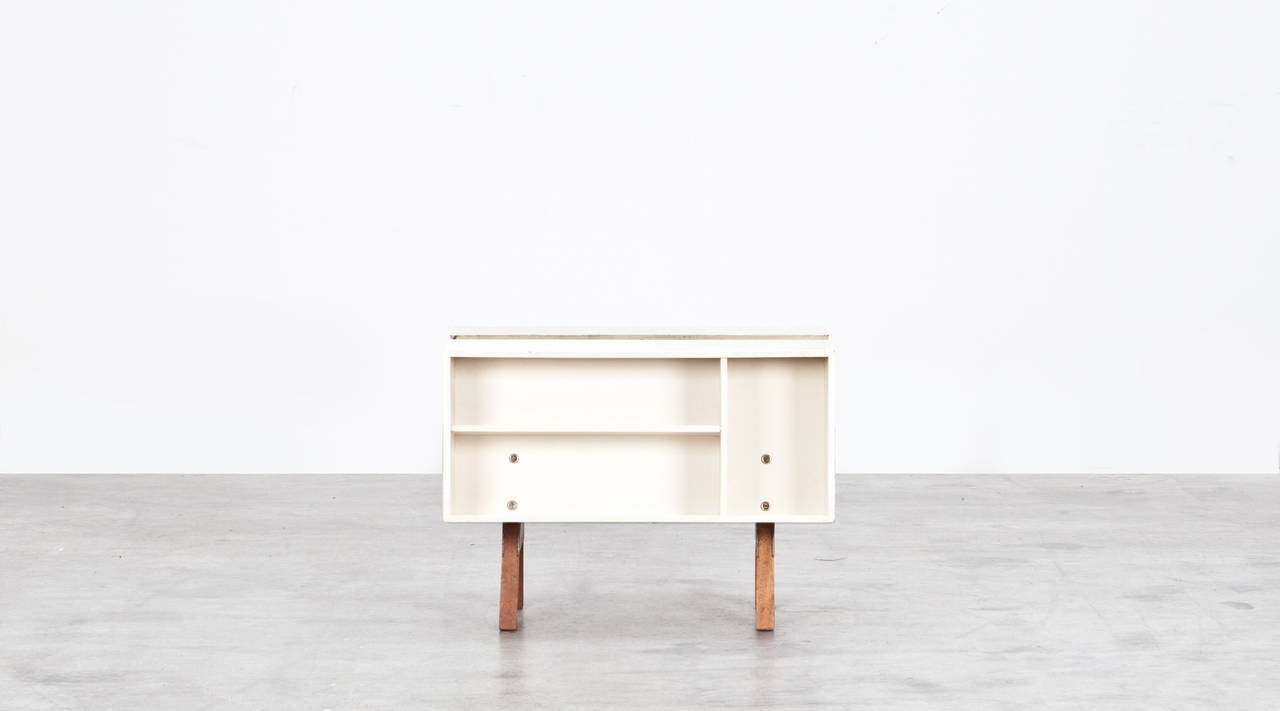 Unique Donkey Mark II side table designed in 1963 after Jack Pritchard asked Ernest Race to redesign the original Riss design. Serves as a multi functional unit with shelf and storage space on both sides. Manufactured by Isokon.

 A key figure in