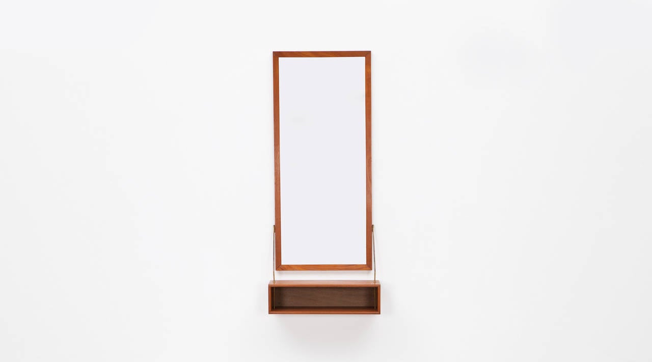Finely made Mirror with additional shelf in teak designed by Hans Agne Jakobsson. The shelf is held by nice brass rods. Manufactured by Hans Agne Jakobsson AB.