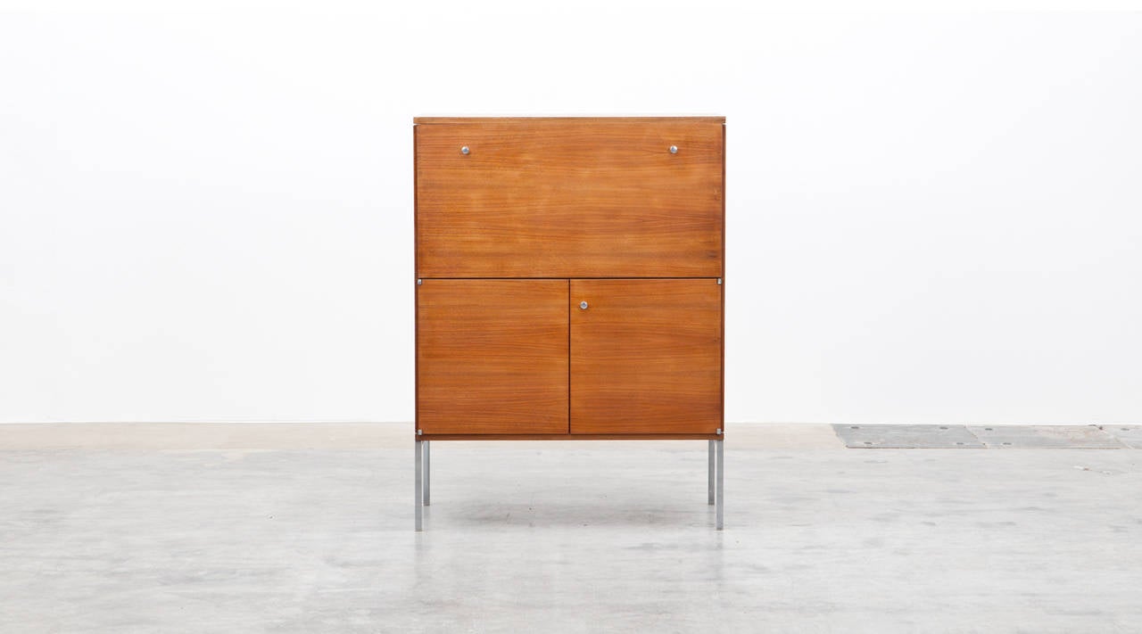 Rare Herbert Hirche highboard with teak veneer corpus and three doors stands on brushed chromium-plated steel base. The design is from the early 1960s and it is manufactured by Holzäpfel. 

Bauhaus student Herbert Hirche was one of the most