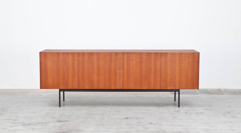Elegant Dieter Wäckerlin sideboard in teak. inlay made out of maple. Painted metal base. Rare Version manufactured by Idealheim Basel. 

Wäckerlin was a cabinet maker, interior architect and furniture designer from Switzerland. His mid-century