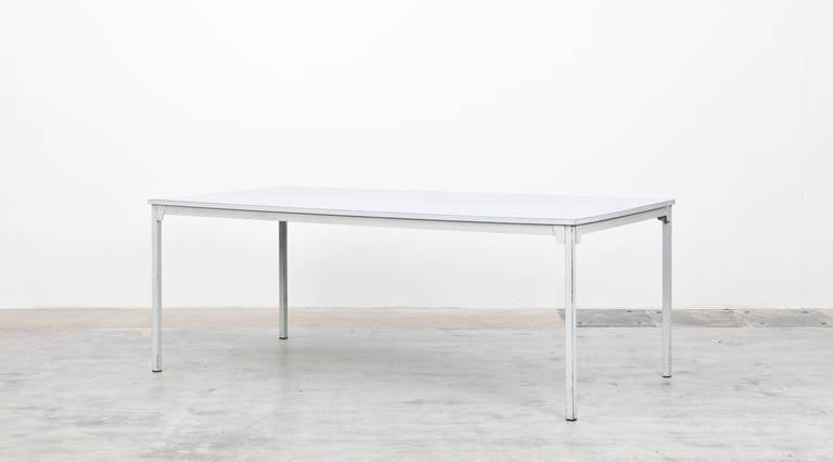 This Table was designed by German modernist Ferdinand Kramer in 1959 for Johann-Wolfgang-Goethe University in Frankfurt am Main. It has a laminated top hold by a metal base. Manufactured by Otto Kind.