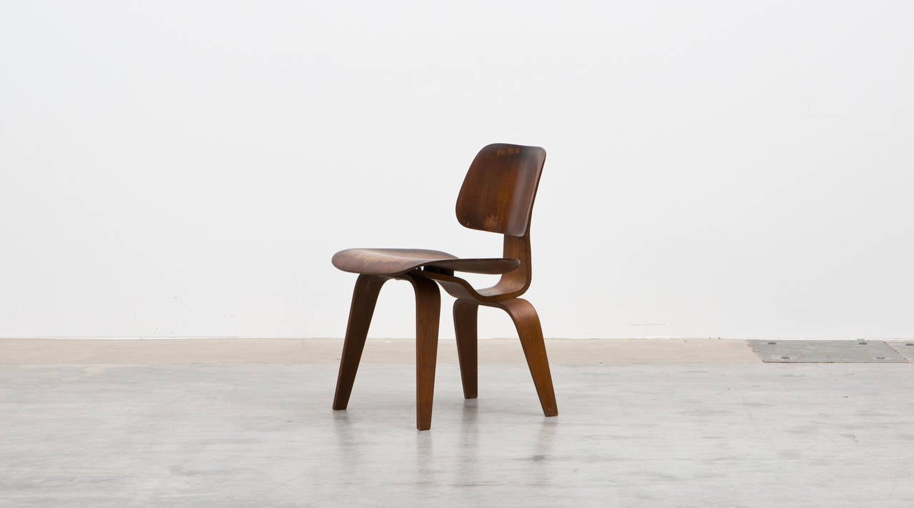 Beautiful und really rare DCW chair designed by Charles & Ray Eames. The chair is made out of walnut and has a beautiful and unique patina. Manufactured by Evans in 1945.

Together with his wife Ray Eames (1912–1988) he significantly contributes to