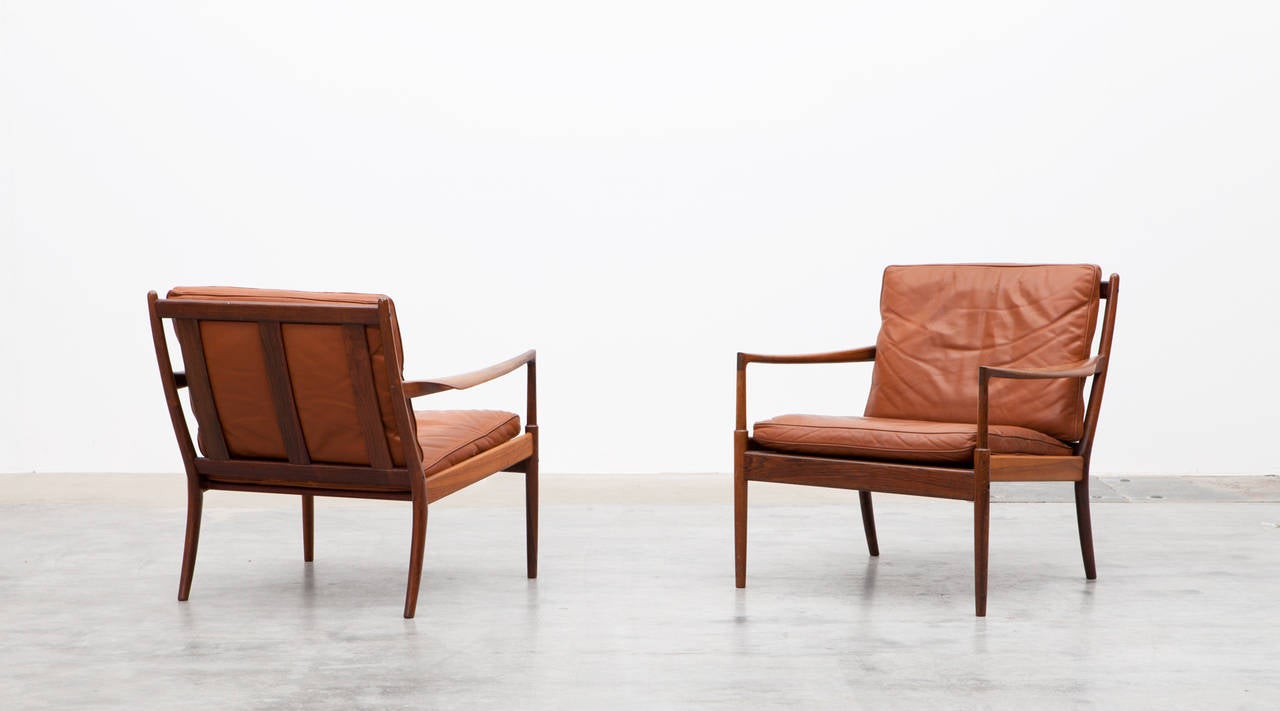Wonderful examples of this sought after chair in rosewood with amazing patinated cognac leather. The lounge chairs were designed by Ib Kofod-Larsen circa 1960-1965. Manufactured by Olaf Person. 