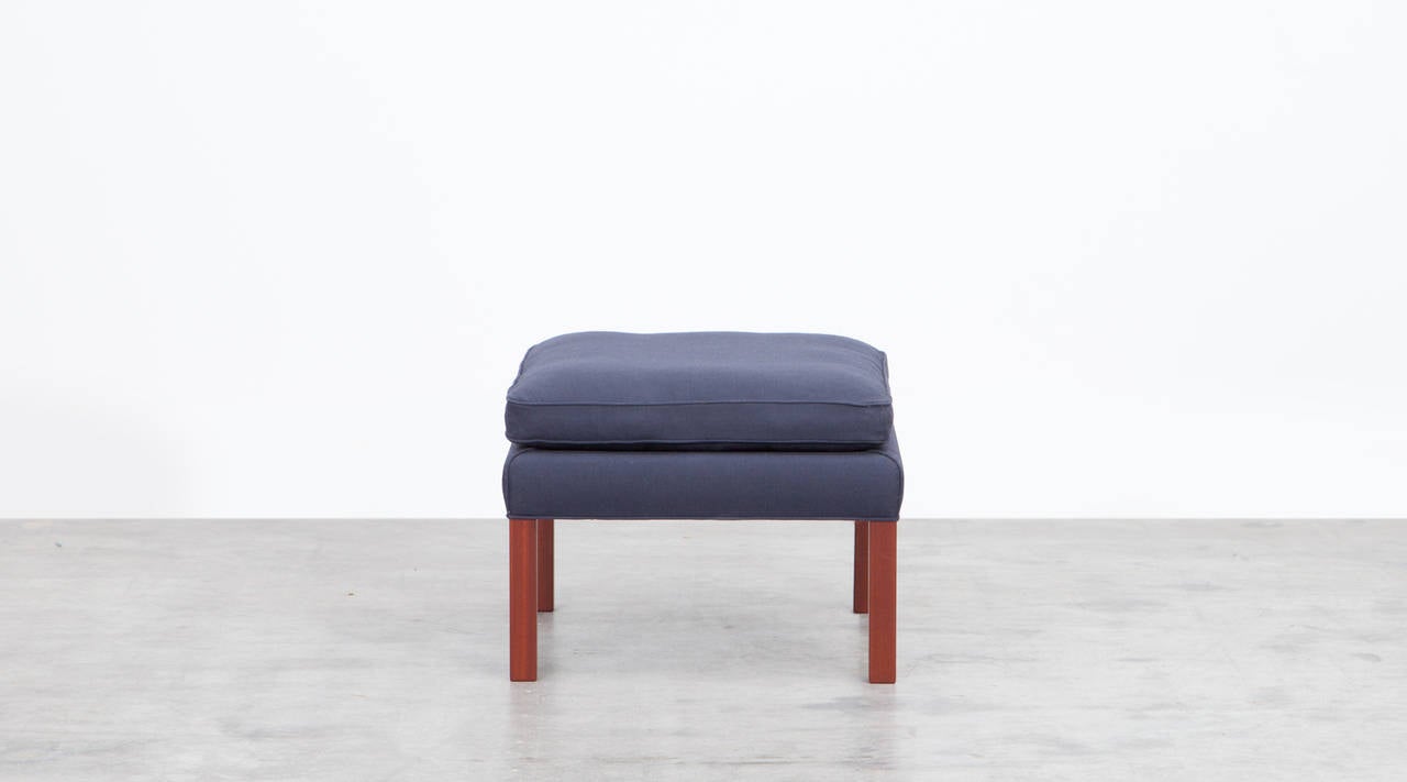 A beautiful pair of square Ottomans in blue fabric on wooden legs by Danish designer Børge Mogensen. The fabric is in excellent condition. Manufactured by Fredericia Stolefabrik.