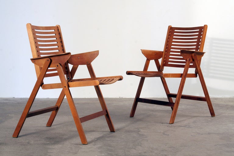 Pair of wooden folding chairs with armrests, 