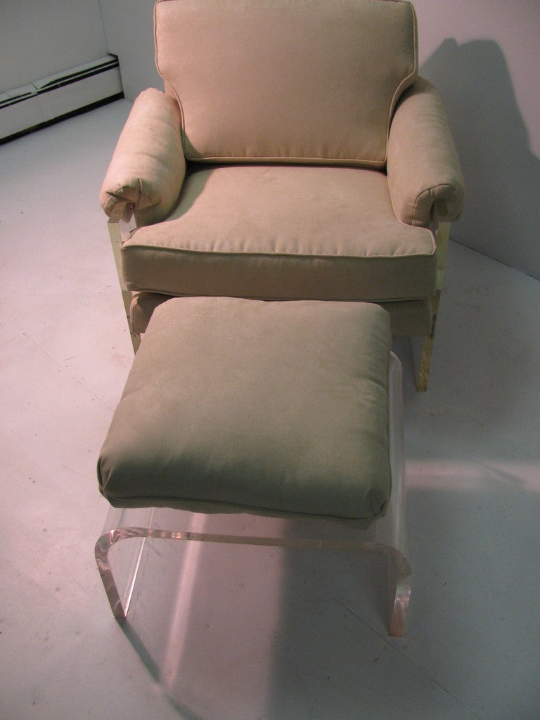 Rare midcentury Lucite armchair with ottoman, reupholstered in a pale suede. Very comfortable.