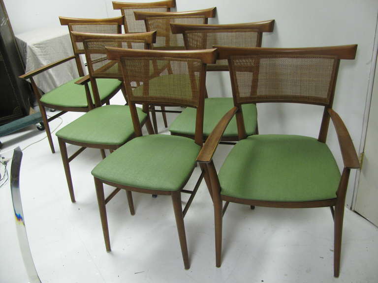 Fabulous set of seven chairs with two armchairs in the group. Asian influenced in their design by Paul McCobb. Original finish is in remarkable condition along with caned rattan backs. Vinyl seats intact but easily updated.