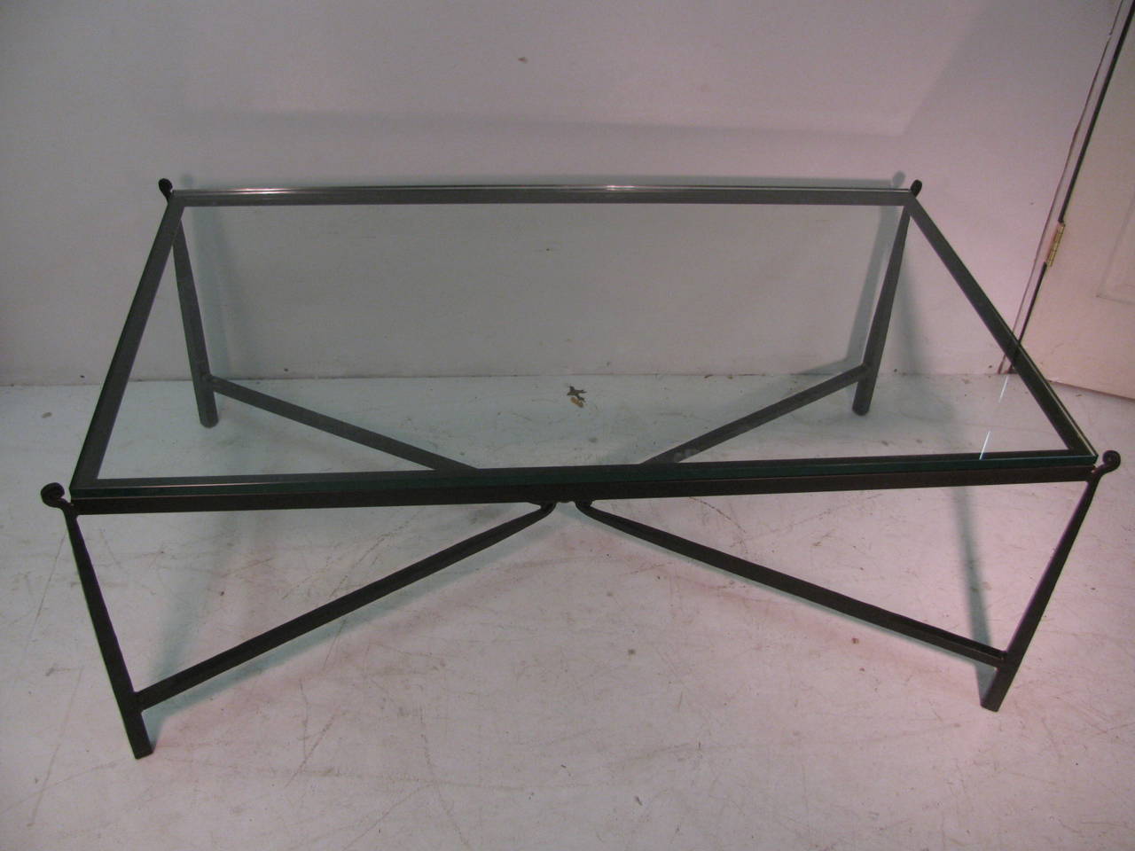 Simple and elegant hand-wrought iron cocktail table. Large and rectangular in shape with a dimensional piece of glass. X stretcher connecting the legs. All inquiries please call or just press 