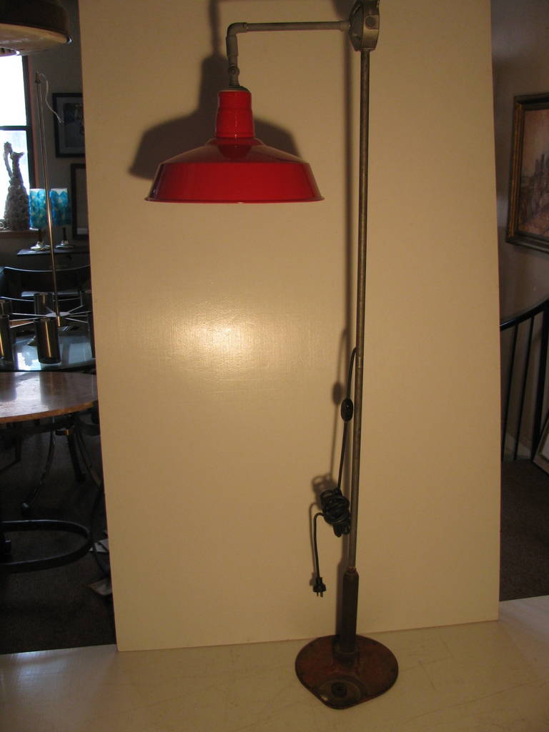 One of a kind Industrial Floor Lamp. Comprised of various parts to accommodate a machine shop. Heavy Cast Iron Base which supports adjustable enameled shade.