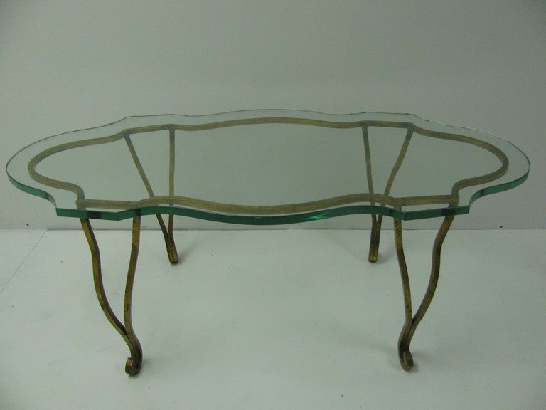 Beautiful and decorative gilt iron table with a dimensional glass top. Rare shape, a Mid-Century interpretation of an 18th Century, French design. Please call in advance for an appointment or if you have any questions.