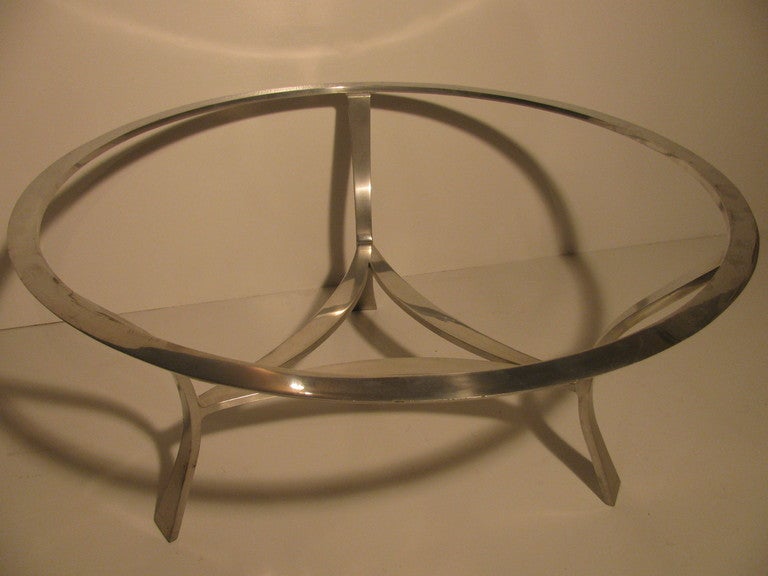 Polished extruded satin aluminum table constructed in a rare Tri-Form design. Arched legs connected with a triangular stretcher. Classic in it's elegant form. Original glass in very good condition, with minor wear.

Please call in advance for an