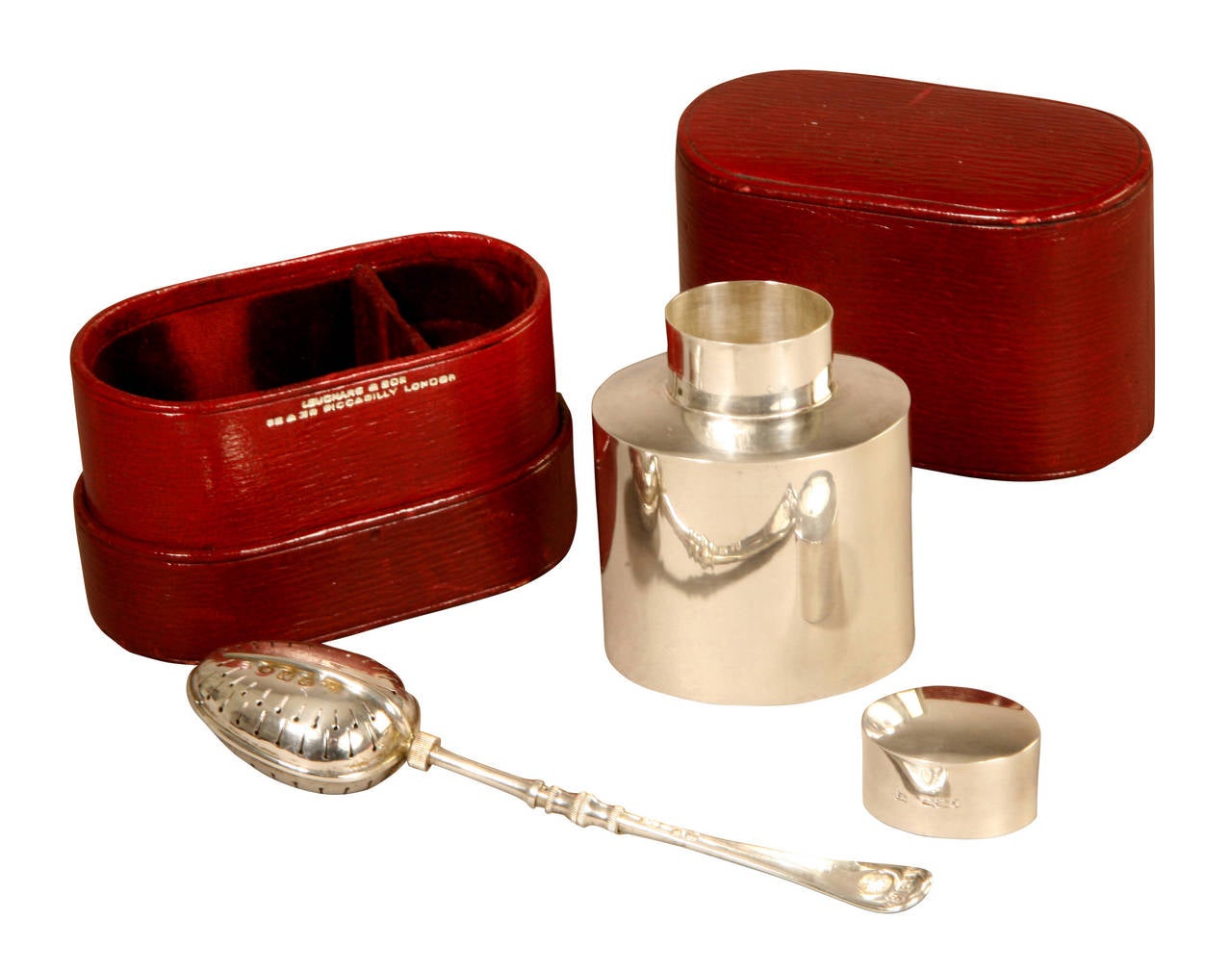This silver Tea Caddy and Spoon Infuser fits neatly into a small red leather case which is stamped in silver with Leuchars & Son, 38 & 39 Piccadilly London. The Caddy is hallmarked for the Sheffield silversmith Harry Atkin, 1892 and the Infuser for