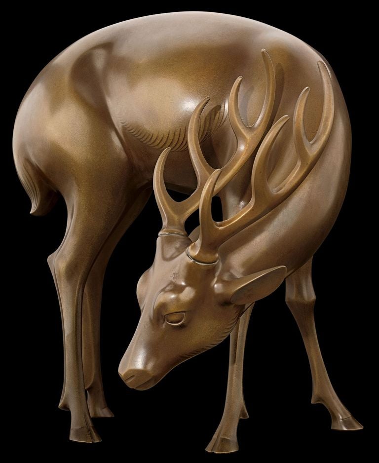 Okimono or sculpture in the form of a grazing, modernist stag. Of cast yellow bronze. Signed on the reverse with a cast seal-form signature by the artist: Churoku (Neya Churoku, 1897 – 1987). Showa 7 or 1932. 

With the niju-bako or original